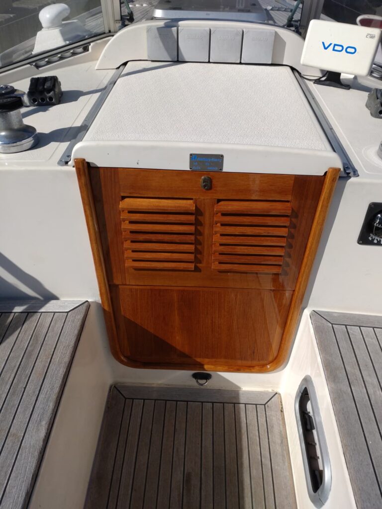 Exklusive Yachtlackierung aus der Werft: Perfekter Spiegelglanz auf dem hölzernen Schottrahmen und den Steckschotten beim Bootseingang.